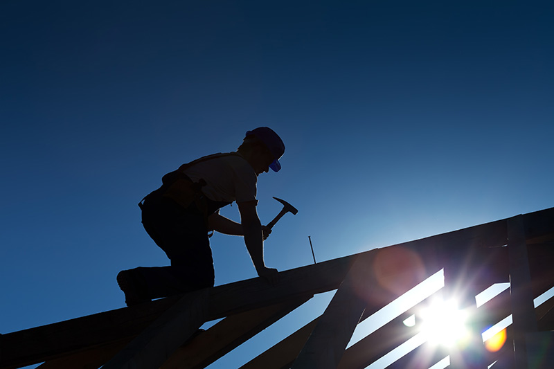 House builder on the roof a house before home inspection services are scheduled 